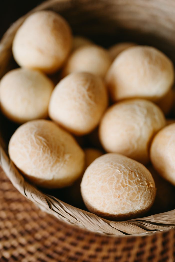 Close-up of traditional Colombian pandebono in a rustic basket, showcasing golden, round breads in an artisanal display.